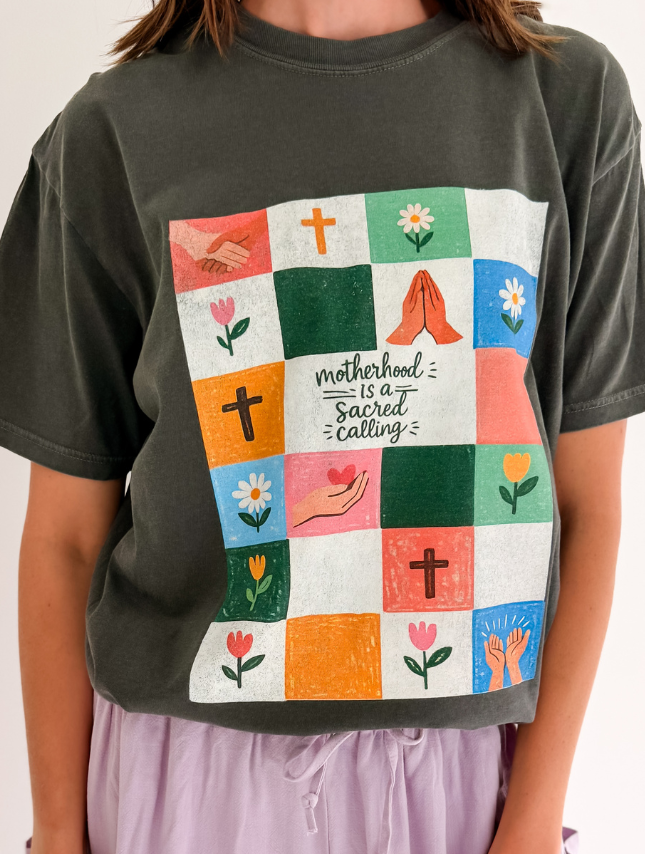 Sacred Calling Tee in olive green featuring a colorful quilt design with floral and religious symbols.
