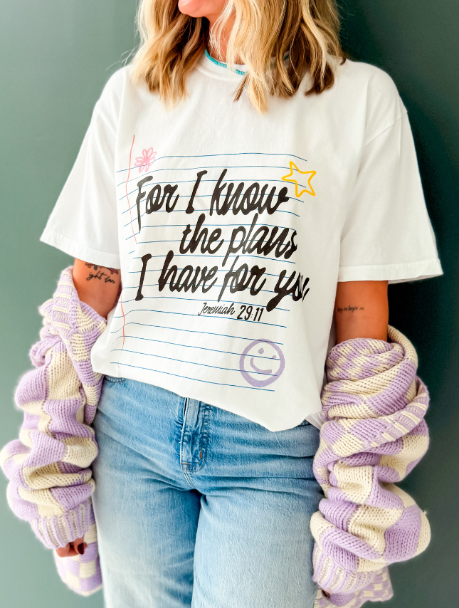 Jeremiah 29:11 tee in white featuring colorful text and a star design, worn with a pastel purple and cream sweater.
