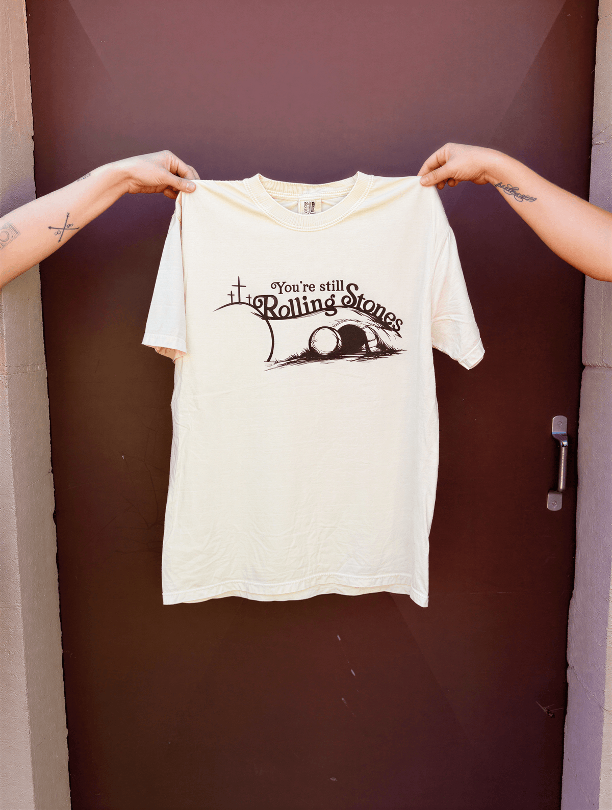 you're still rolling stones tee being held up